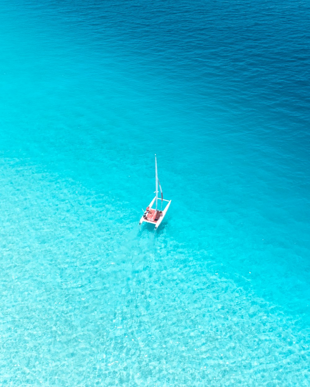 Fotografía de vista aérea de un velero en el cuerpo de agua