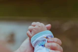A caregiver gently holding a baby, symbolizing essential care programs.