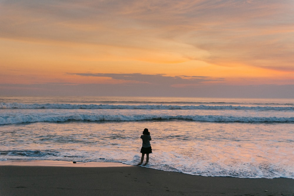 silhouette of woman standing beside seashore