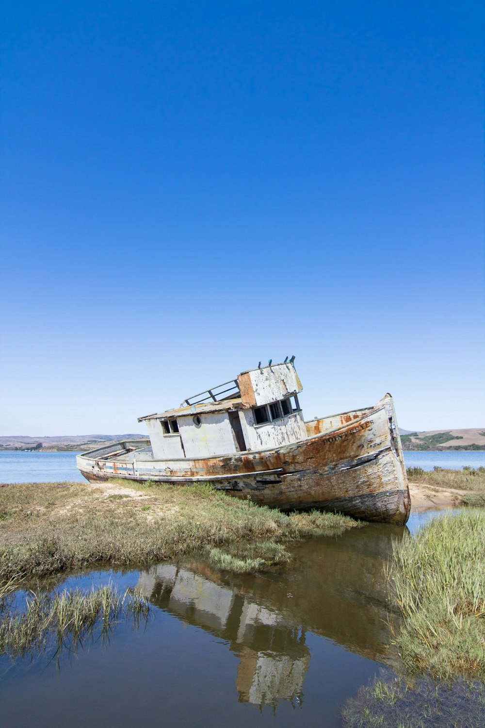 abandoned boat beside green grass field