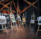 five assorted paintings on easels