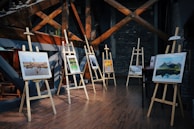 five assorted paintings on easels