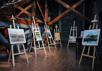 five assorted paintings on easels