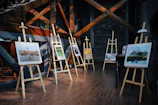 five assorted paintings on easels