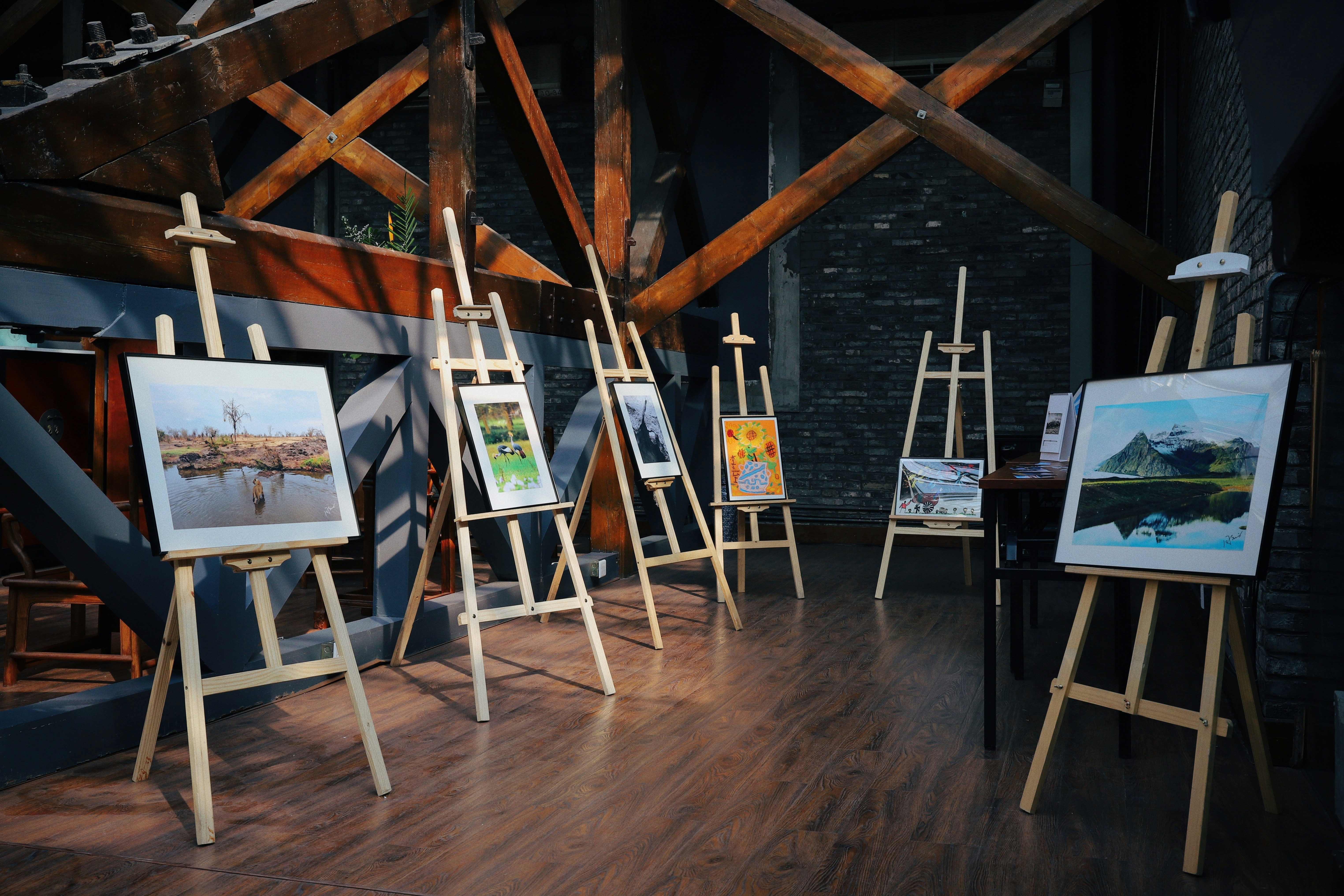 five assorted paintings on easels