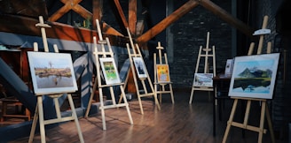 five assorted paintings on easels