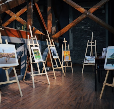 five assorted paintings on easels