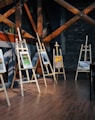 five assorted paintings on easels