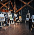 five assorted paintings on easels