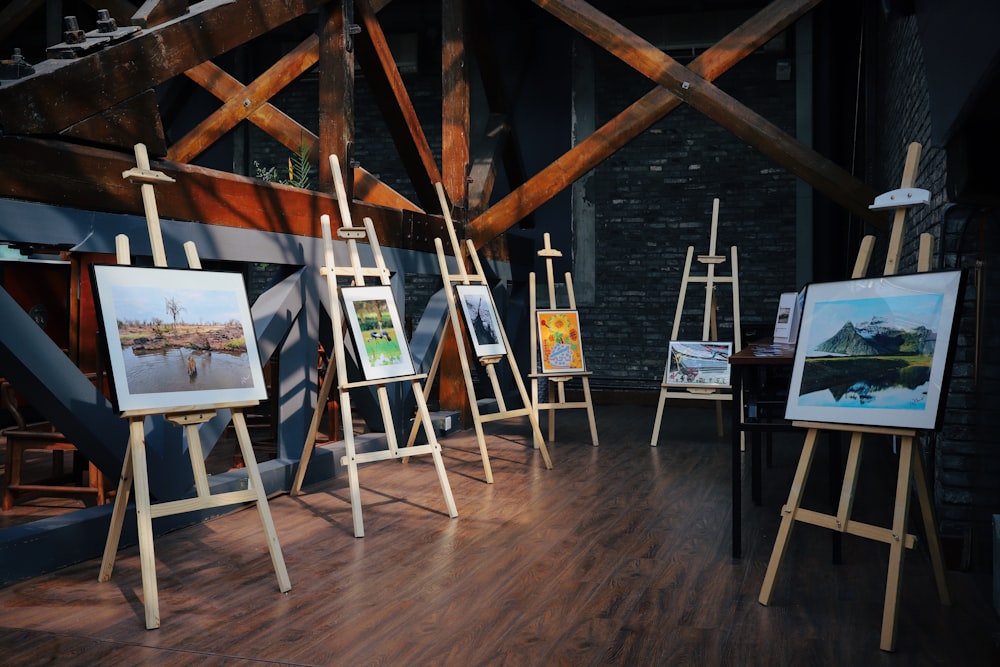 five assorted paintings on easels