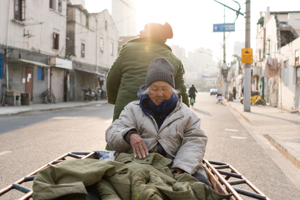 two person on trailer travelling on road during daytime