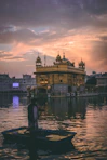 man riding on boat near golden mosque