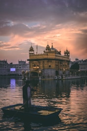 man riding on boat near golden mosque