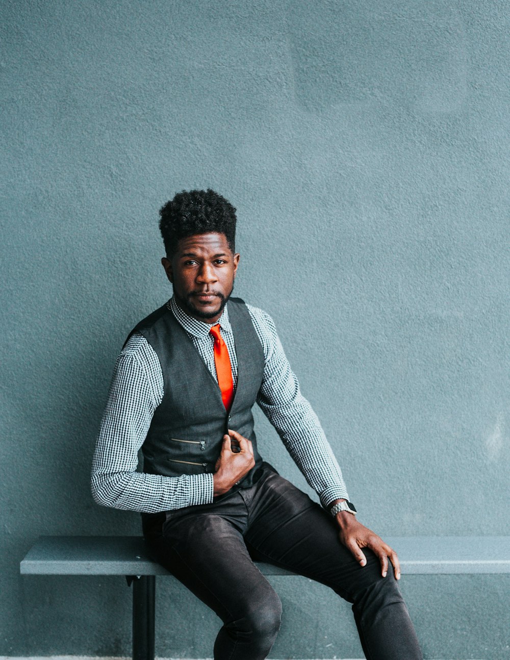 man wearing vest sitting on bench