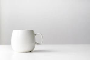 A minimalist mug design with clean lines and subtle geometric shapes on a white surface.