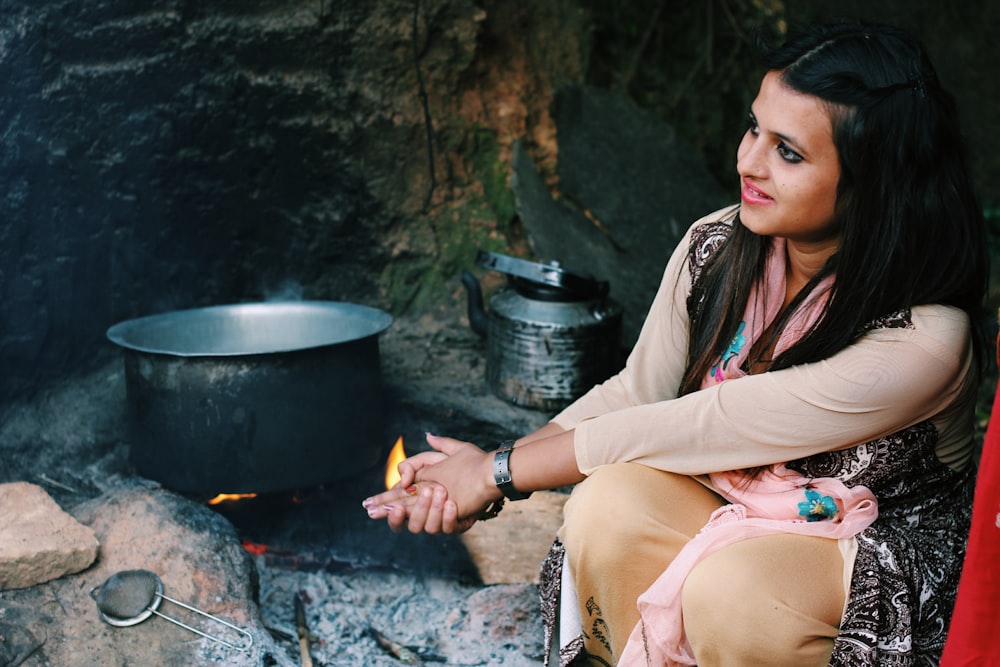 woman sitting near cook pot