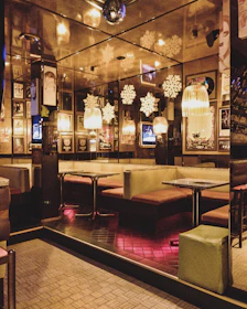 The warm, inviting interior of o'2 temps with glowing lights and guests enjoying a festive evening.