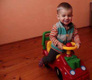 Smiling toddler wearing a colorful, comfortable outfit playing with toys indoors