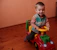 A smiling child playing with colorful wooden educational toys at home.