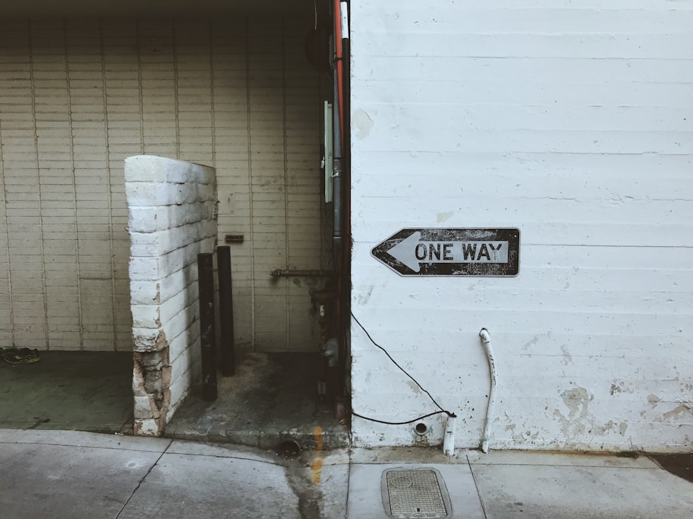 one way street signage on wall