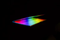 Transparent laptop displaying a vibrant screen with circuitry visible beneath.