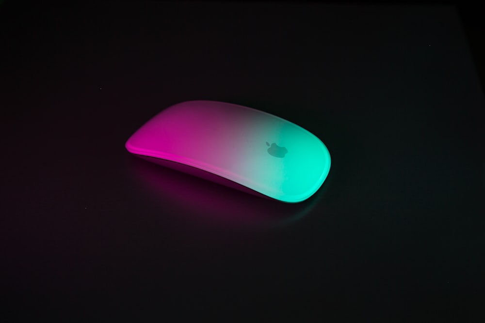 Apple Magic Mouse에 반사된 분홍색과 초록색 빛