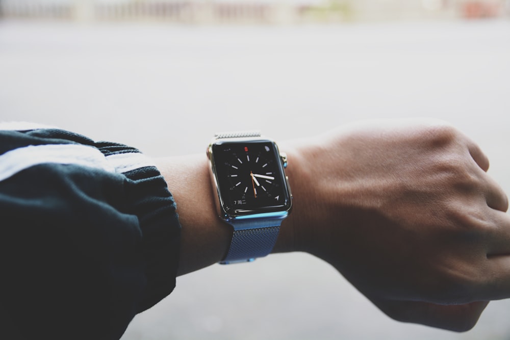 shallow focus photo of person wearing smartwatch watch