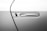 A close-up view of a car door focusing on the sleek, modern handle with a recessed design. The handle is embedded in the car's body, with a minimalist and streamlined appearance, showcasing a metallic finish.