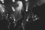 a crowd of people at a concert with their hands in the air