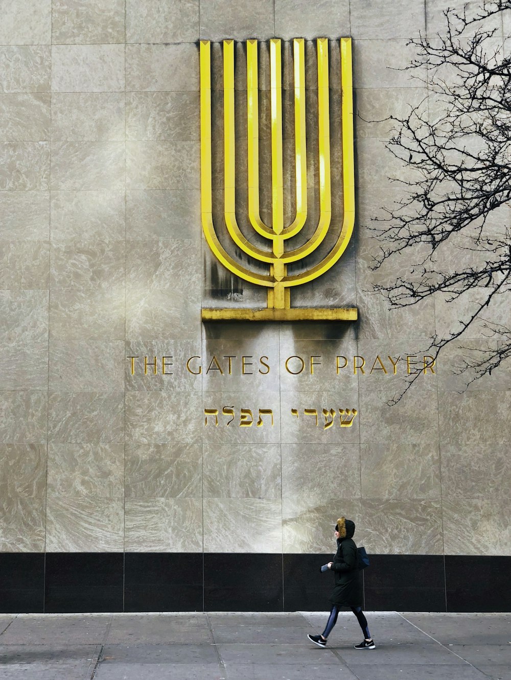 Un uomo che cammina davanti a un edificio con una grande menorah su di esso