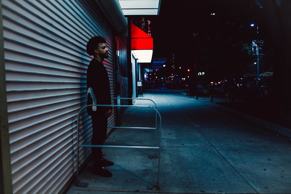 a man standing on a sidewalk next to a building