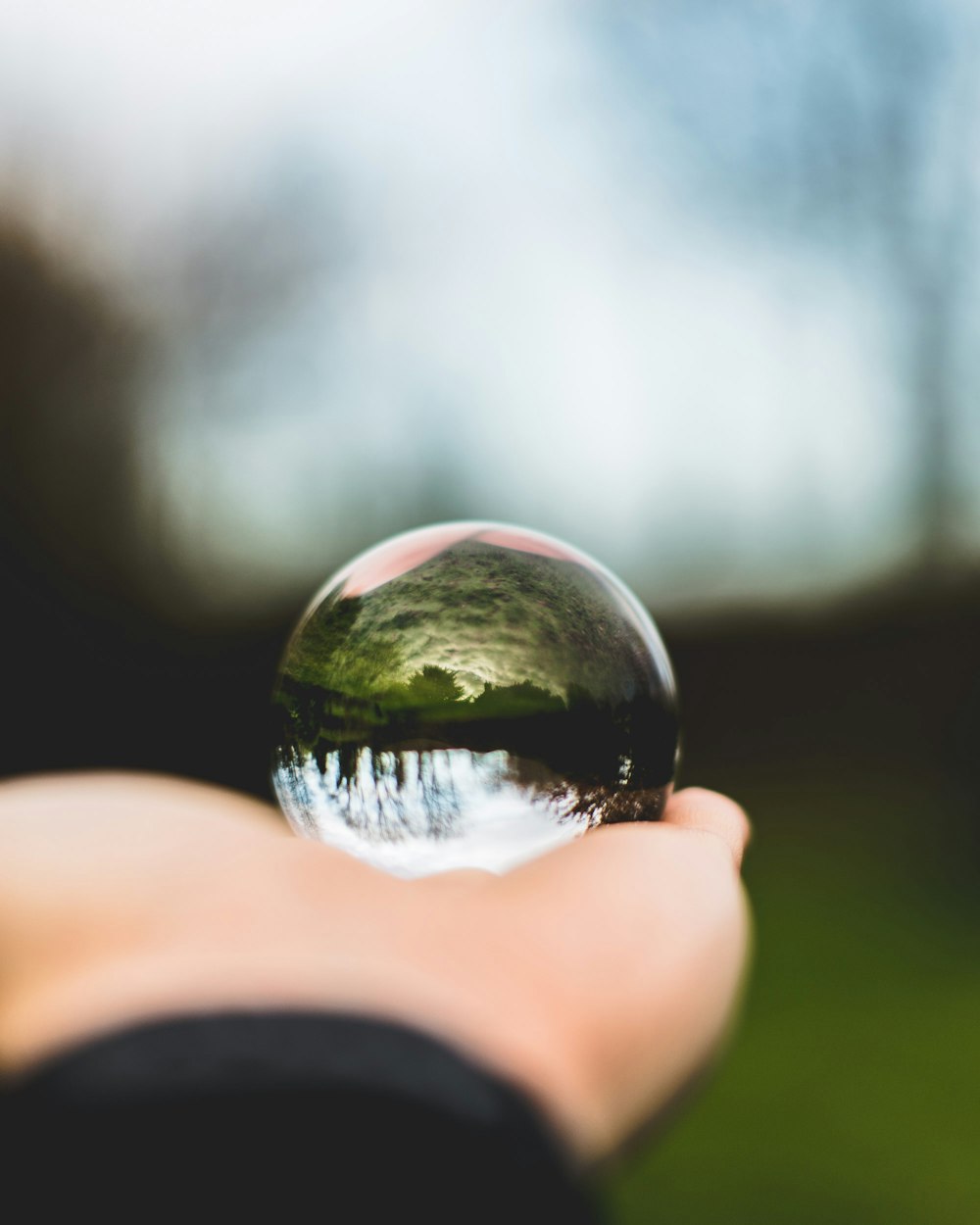 Persona che tiene la sfera di vetro rotonda