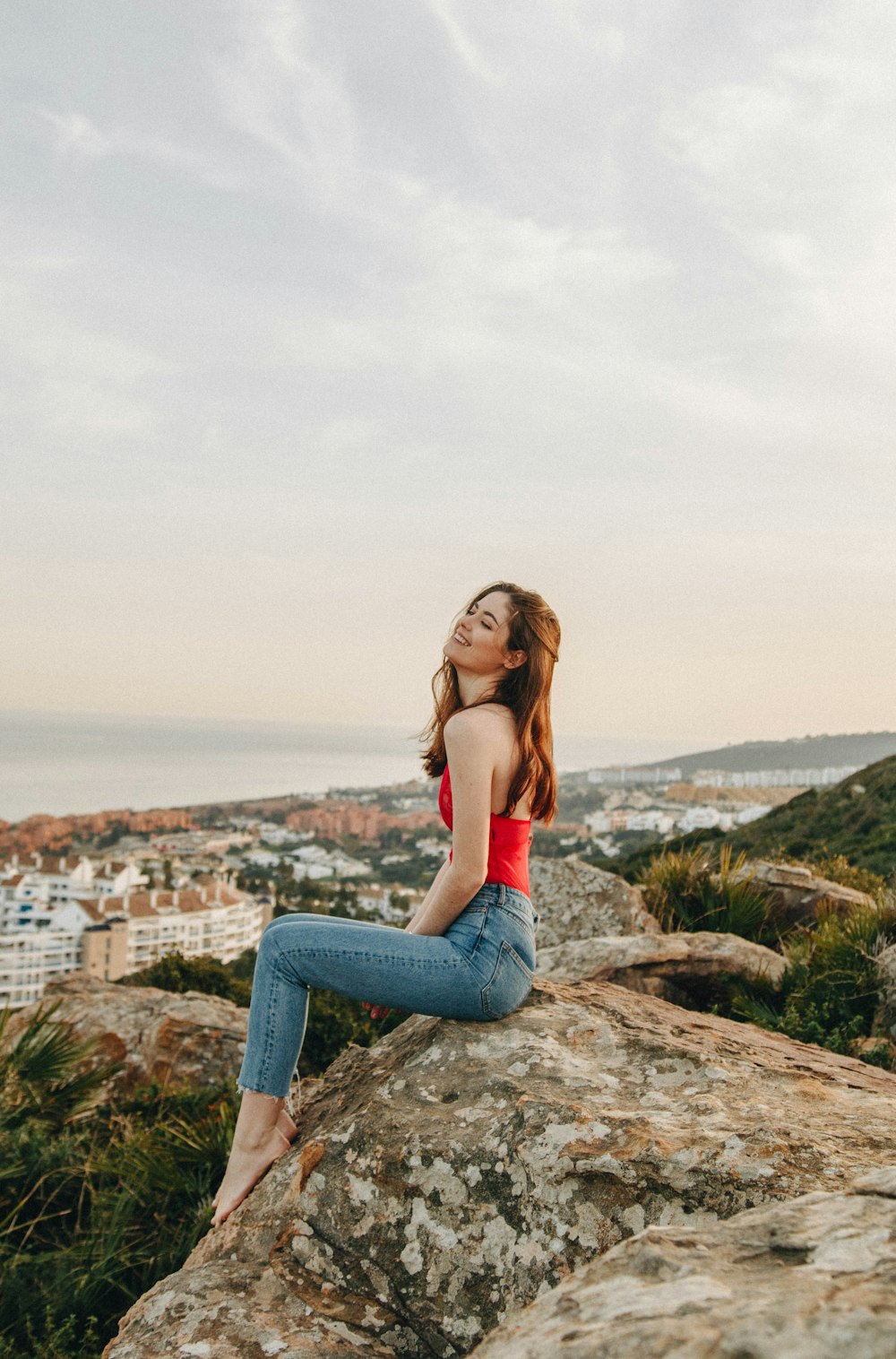 Mujer sentada en la roca durante el día