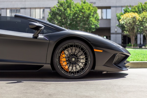 Matte black Lamborghini Aventador wheel and lower body panel showing clean finish