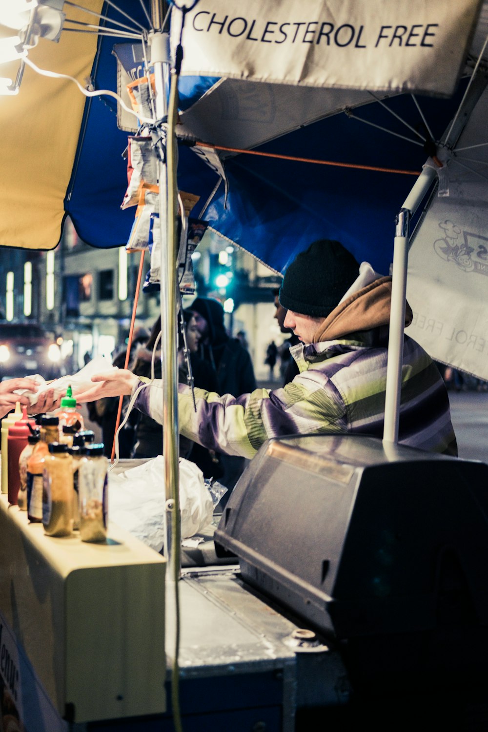 man under umbrella beside table