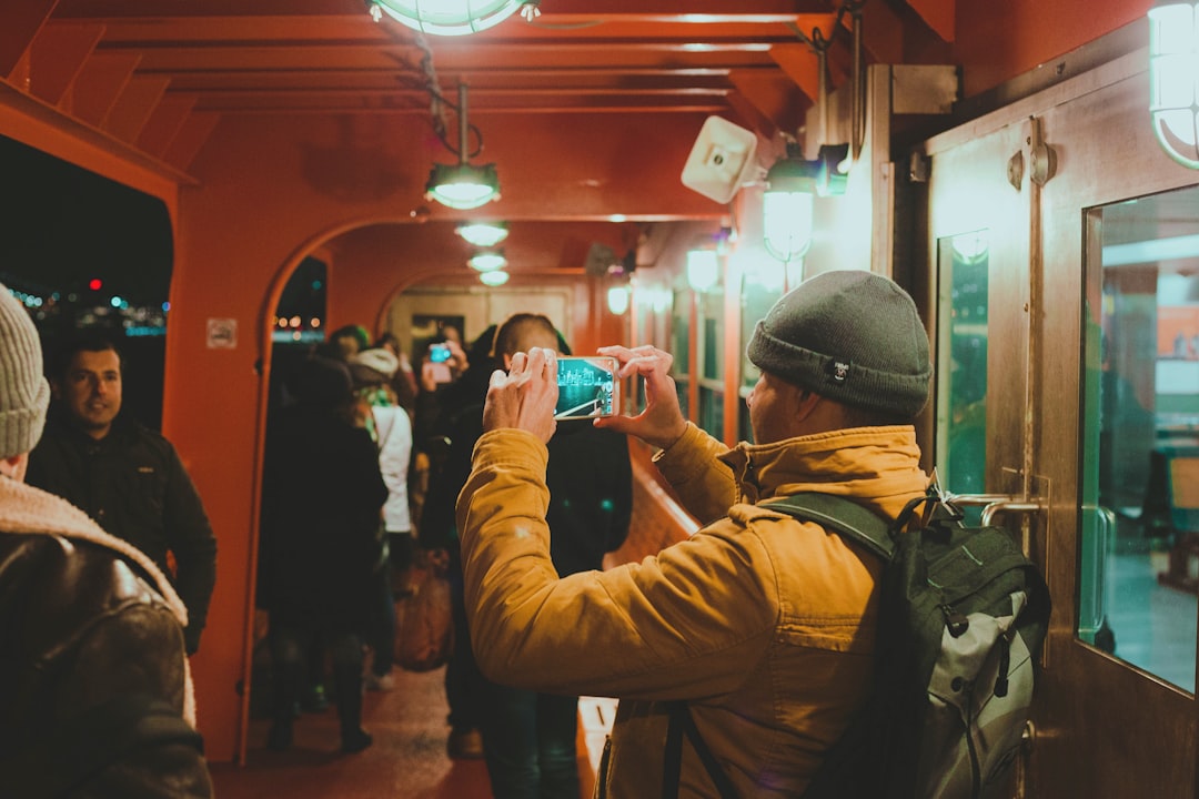 man in brown jacket holding phone