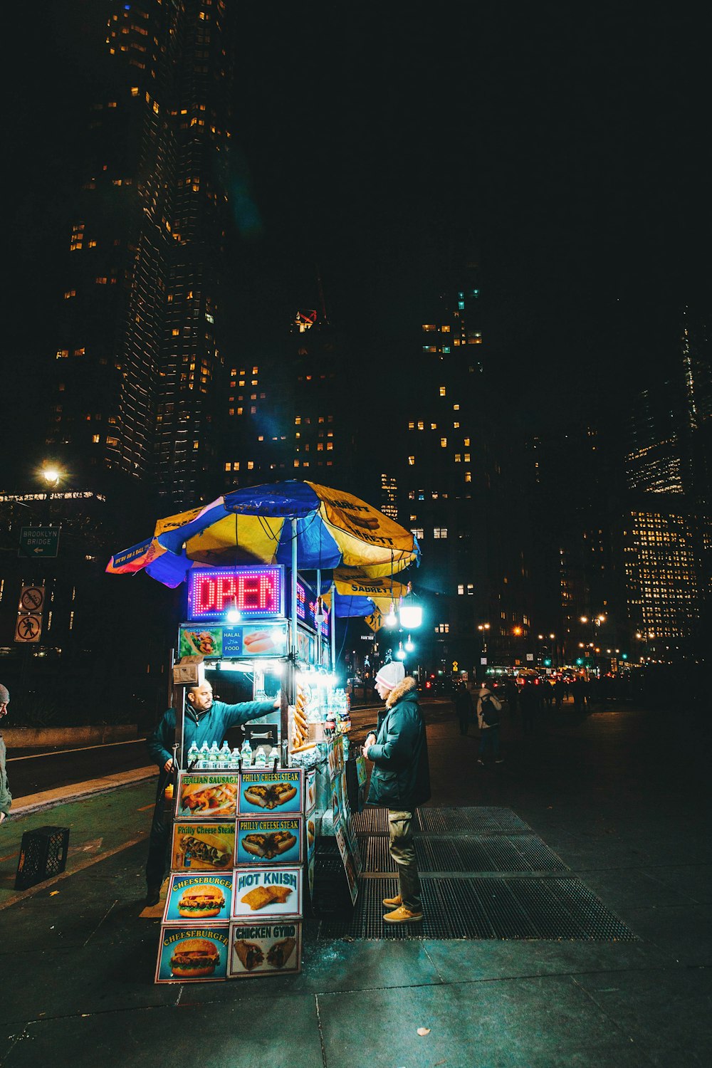 man standing in front of food stand