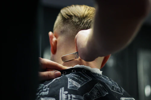 Close-up of a barber trimming a client's hairline with precision