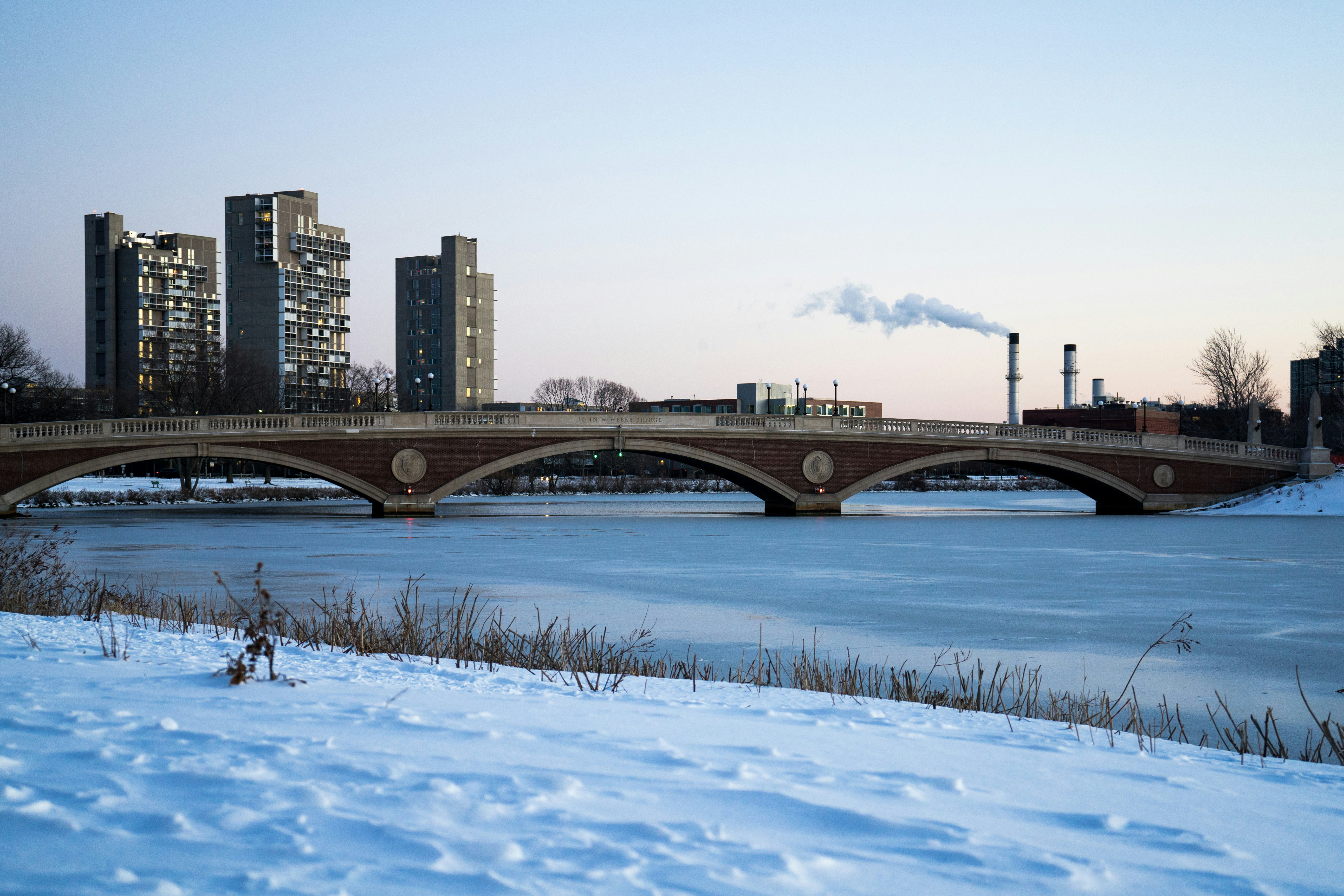 a bridge over a body of water with buildings in the background