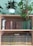Close-up of a beautifully crafted wooden bookshelf filled with books and plants.
