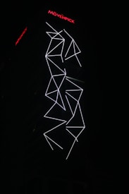 An illuminated building facade featuring white geometric LED light patterns against a dark background. The design appears to be abstract with intersecting lines and angles. The brand name Movenpick is visible at the top in bright red letters.