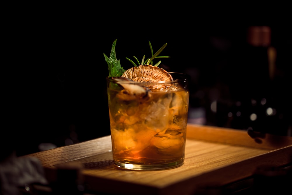 clear glass tumbler on brown wooden tray