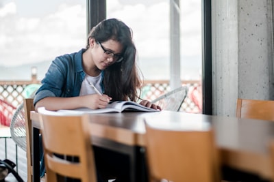 woman writing on book student teams background