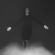 A serene woman surrounded by swirling black and gold mist, symbolizing inner transformation.