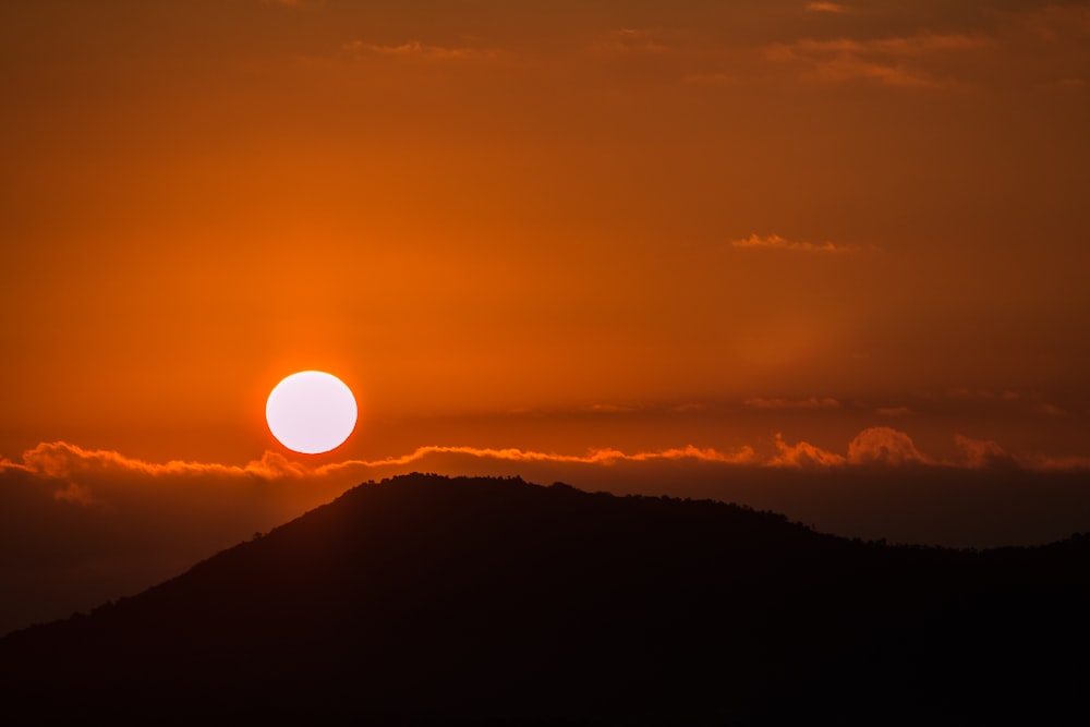 silhouette of mountain under golden sun