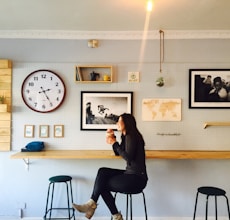 woman sitting on stall near wall mounted desk