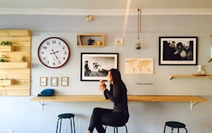 woman sitting on stall near wall mounted desk