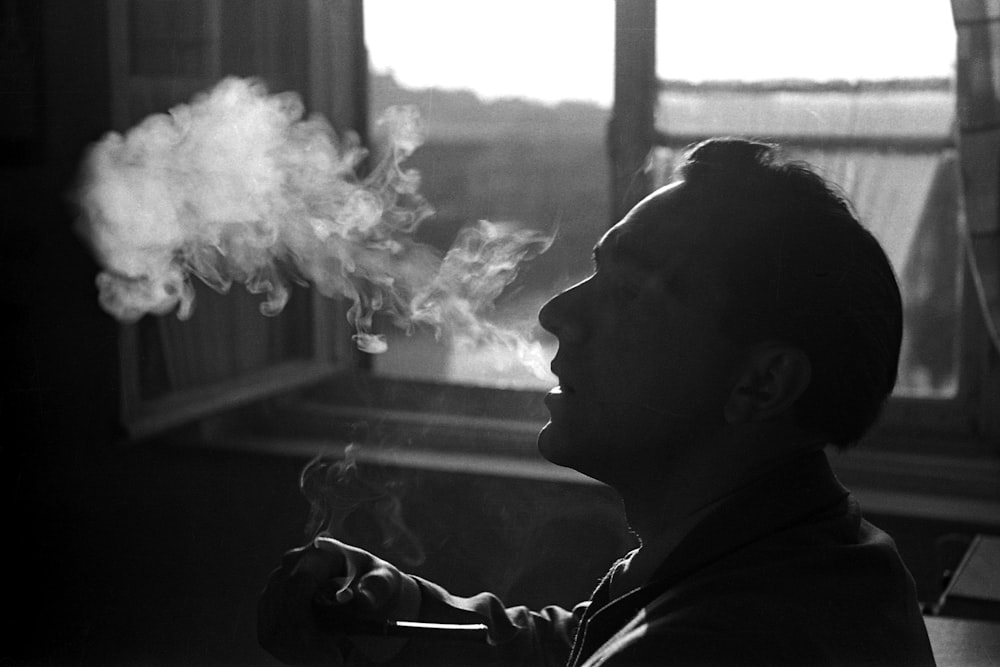 person smoking beside window