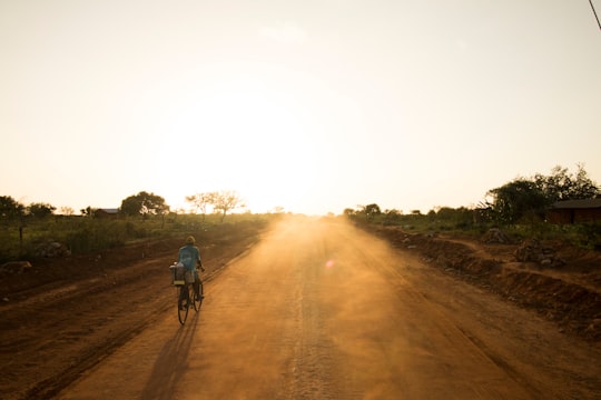 person riding bicycle on rod in Tsavo East National Park Kenya