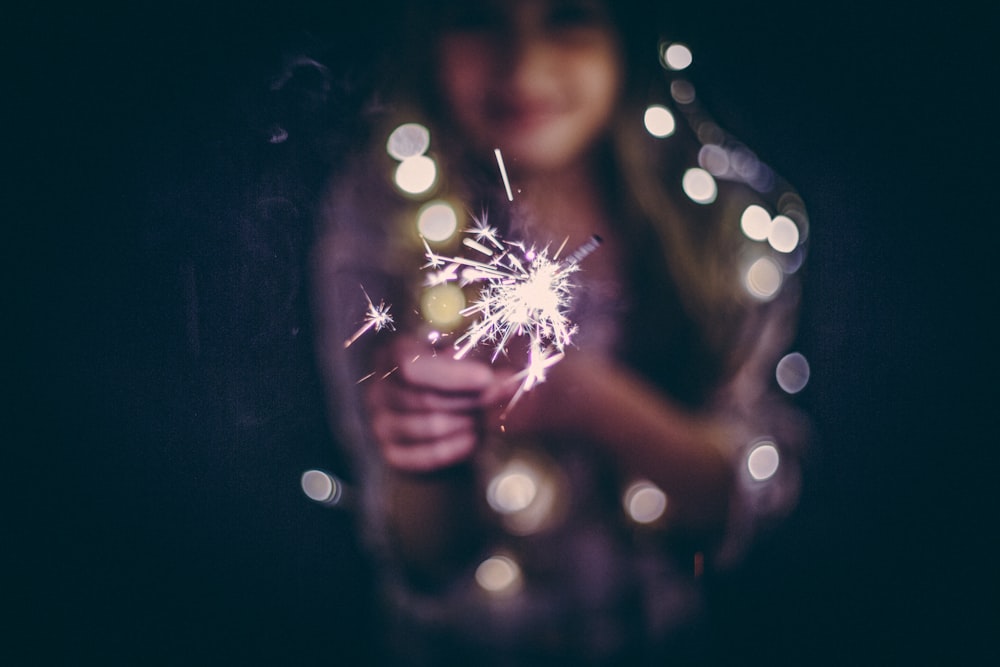 bokeh photography of woman holding sparkler